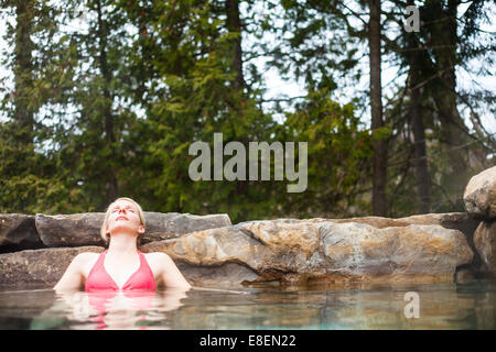 Young Woman Relaxing in a Outdoor Nordic Spa, in the forest. Stock Photo