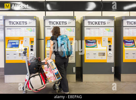 Female tourist buying ticket for Metro train to Newcastle city centre from Newcastle Airport Metro station. England. UK Stock Photo