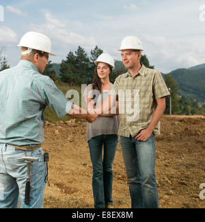 group of young caucasian architects shaking hands on construction site Stock Photo