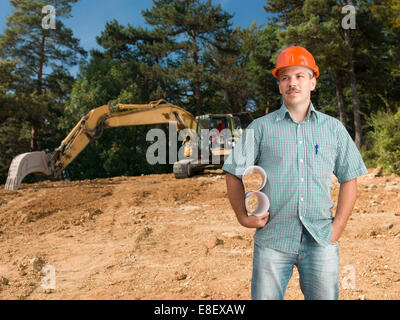 front view of architect on construction site holding blueprints Stock Photo