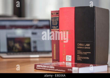 Hong Kong Club Building, Hong Kong, 7th Oct, 2014. Photo displaying a number of reference books relating to China Law, with the 'Occupy Central' news feed in the background. Stock Photo