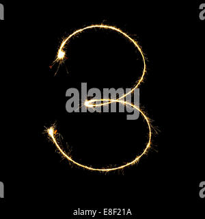 burning sparkler stick and writing sparkling text . number three  isolated on black background Stock Photo