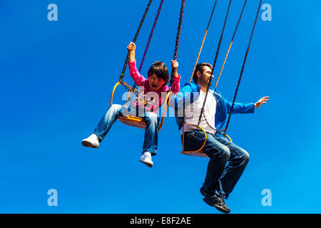 People on carousel ride, man toddler, father and daughter, child crying Stock Photo