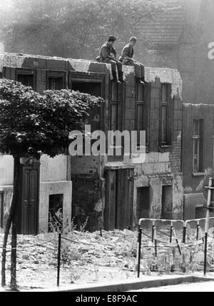 Border officials of GDR watching house demolitions on Bernauer Street in Berlin on 10th august 1965. The Federal Republic of Germany and the German Democratic Republic were split into west and east by an iron curtain from 13th August 1961, the day of the building of Berlin Wall, to the fall of the wall on 9th November 1989.