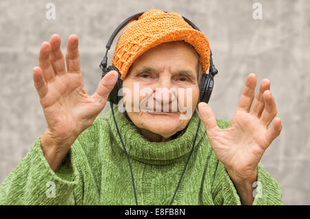 Elderly woman with headphones listening to music. Stock Photo