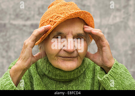Elderly woman holding hand close to head. Headache problem. Stock Photo