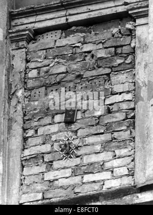 A Christian hymn book and flowers have been placed in a bricked window of a border house in Bernauer Street on the 13th of October in 1961 by an inhabitant of East Berlin. Stock Photo