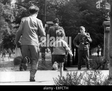 A father and his little son run in the direction of East Berlin after the surprising sealing off of West Berlin by the rulers of the GDR on the 13th of August in 1961. The People's Police of the GDR had allowed to bring back the child, which was on a visit to West Berlin. Stock Photo