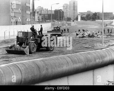 With heavy equipment, workers from East Berlin dismantle tank traps at the Berlin Wall near the Bethaniendamm in the district Kreuzberg in West Berlin on 1 August 1985. From 13 August 1961, the day of the building of the Berlin Wall, to the fall of the Berlin Wall on 9 November 1989, the Federal Republic of Germany and the GDR were separated by the Iron Curtain between West and East. Stock Photo