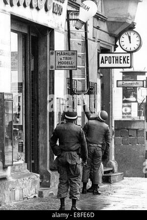 Soldiers of the US Army transporting bed frames into an apartment at checkpoint Friedrichstraße, called Checkpoint Charlie, on 1st November 1961 in Berlin. From this apartment the US Army has a perfect view on the East Berlin side of the border. From 13th August 1961, the day of the building of the wall, until the fall of Berlin Wall on 9th November 1989 the Federal Republic of Germany and the GDR were split by the 'iron curtain' between west and east. Stock Photo