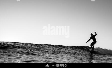 Silhouette of a surfer surfing, California, USA Stock Photo