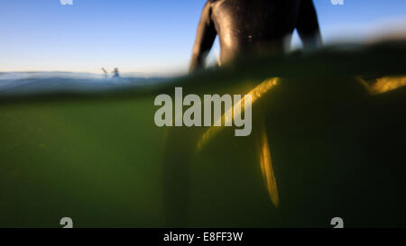 Close-up of a Man sitting on a surfboard waiting to catch a wave, California, USA Stock Photo