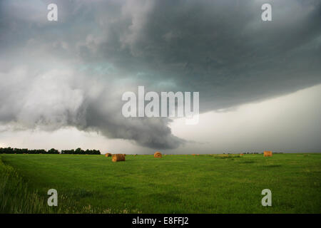 Tornado over field with hay bales, Tornado Alley, Nebraska, USA Stock Photo