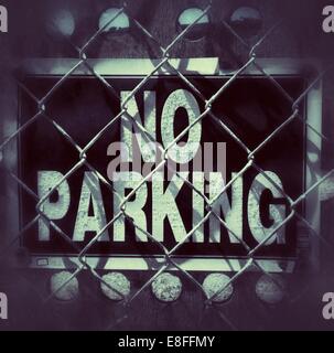 View of No parking sign behind chain link fence Stock Photo