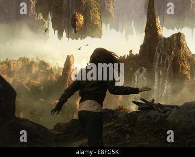 Young woman running through mystical landscape Stock Photo