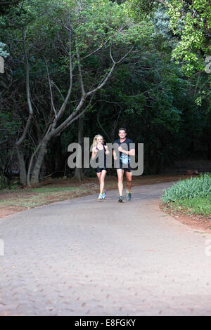 Couple jogging along footpath Stock Photo