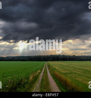 Storm clouds over a rural road, Sweden Stock Photo