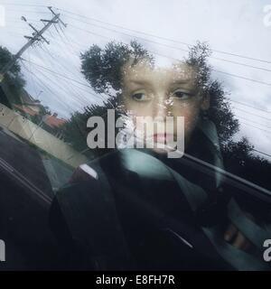 Boy sitting in car seat looking through the window