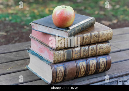 Apple on top of a stack of old books Stock Photo