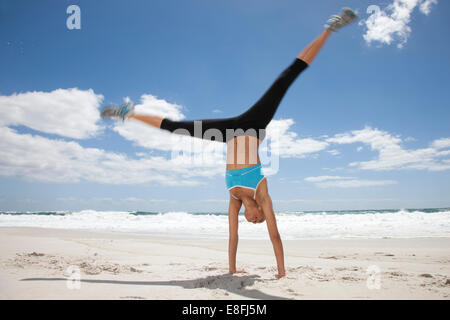 Young woman doing handstand on beach, Cape Town, Western Cape, South Africa Stock Photo