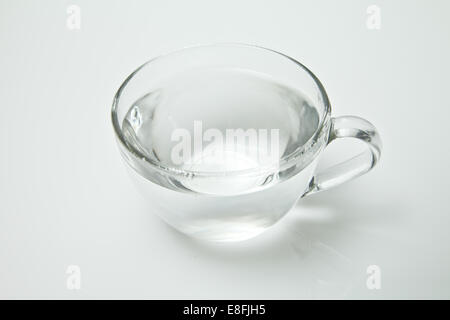 Glass tea cup filled with hot water on a white background Stock Photo