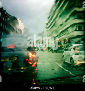 UK, London, Westminster, Knightsbridge, Taxi and car in wet weather Stock Photo