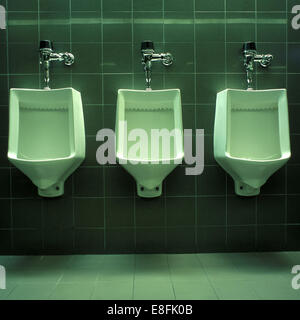 Three Urinals in public restroom Stock Photo