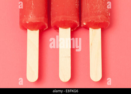 Close-up overhead view of three ice lollies in a row on a table Stock Photo