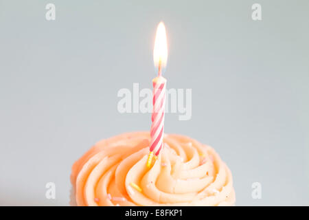 Close-up of a cupcake with buttercream icing and a birthday candle Stock Photo