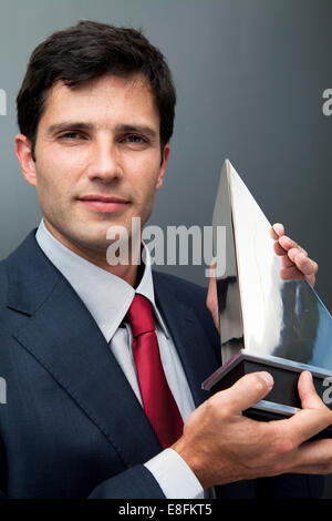 Businessman holding trophy Stock Photo