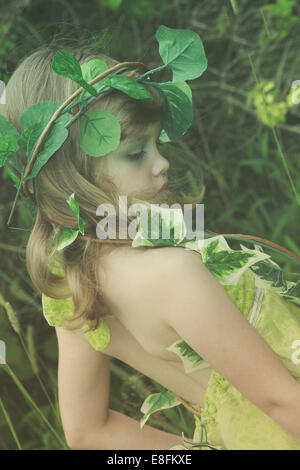 Girl standing in forest dressed as tree fairy Stock Photo
