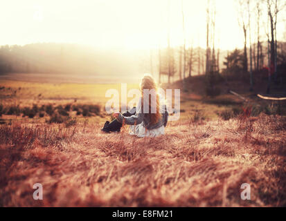 Rear view of woman sitting in a meadow, Norway Stock Photo
