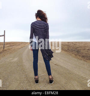 Rear view of a Woman standing in a road Stock Photo