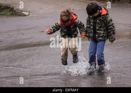 Spain, Boys jumping in rain Stock Photo