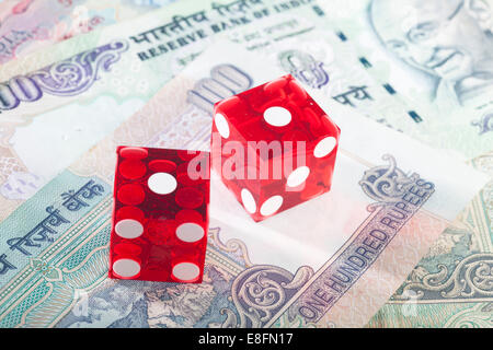 Red dice on Indian bank notes Stock Photo