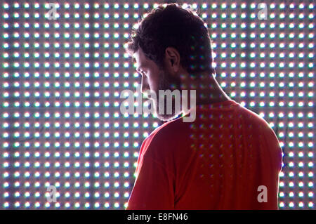Rear view of a Man standing in front of an LED screen Stock Photo