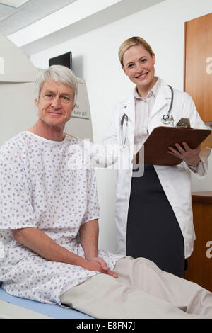 Female doctor and male patient in hospital scanning room Stock Photo