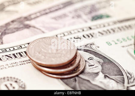 Close-up of a stack of quarters on American banknotes Stock Photo