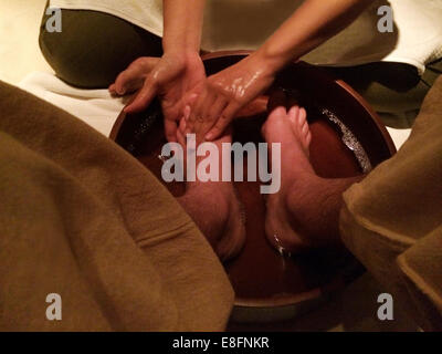 Man having feet washed and massaged in spa Stock Photo