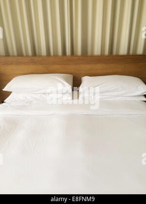 Bed with four pillows and duvet Stock Photo