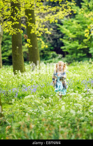 UK, Warwickshire, Rugby, Girl (4-5) running in woods Stock Photo
