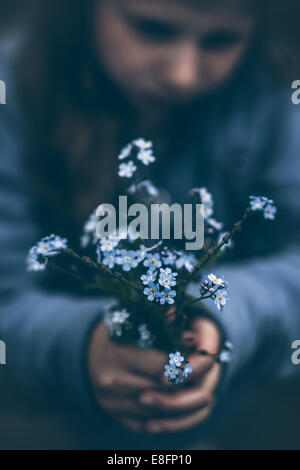 Girl holding bouquet of forget-me-not flowers Stock Photo