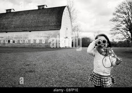 Girl looking through binoculars, USA Stock Photo