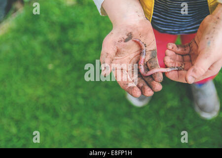 Close up of a boy holding an earthworm in his hands, USA Stock Photo