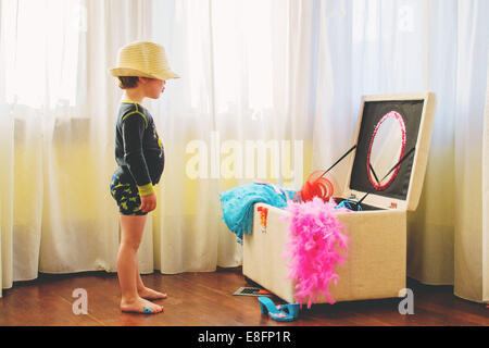 Boy wearing a hat standing by dressing up box Stock Photo