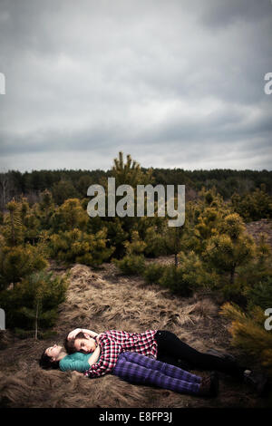 Teenage couple lying in a meadow embracing Stock Photo