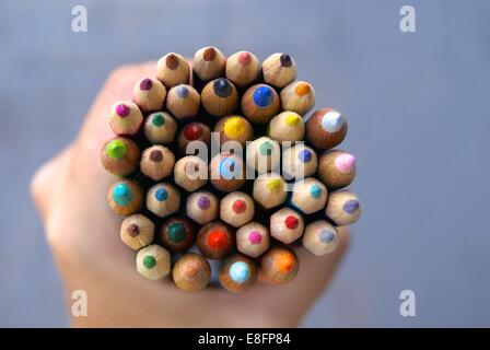 Human hand holding colored pencils Stock Photo