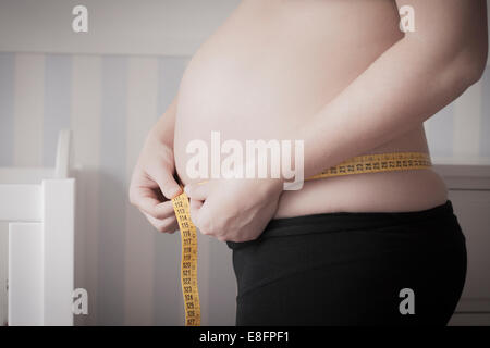 Pregnant woman measuring her belly Stock Photo