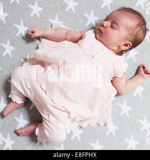 Baby girl lying on back sleeping Stock Photo