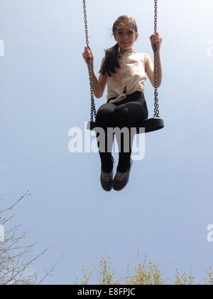 Girl sitting on a swing Stock Photo
